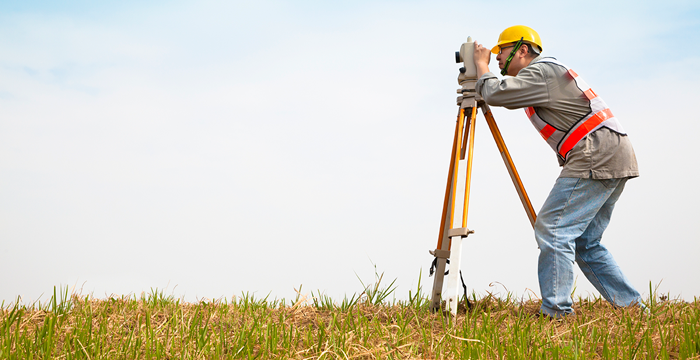 A surveyor in an open field.