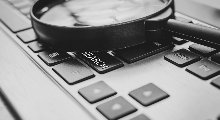 Magnifying glass on a laptop keyboard.