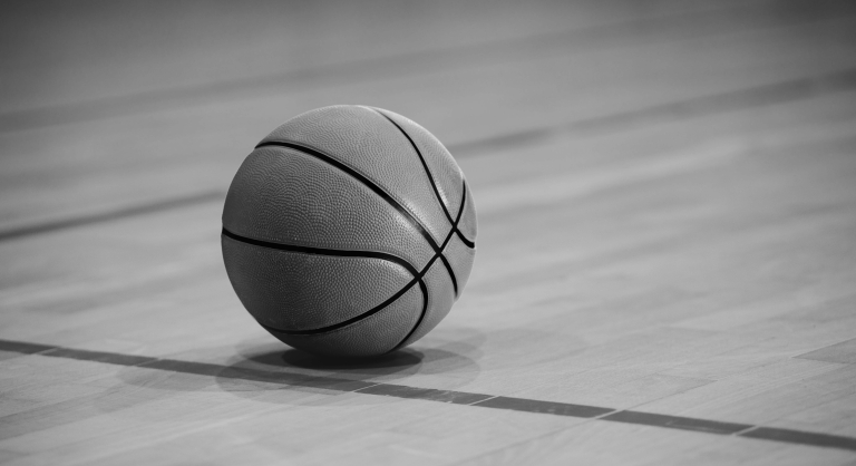 Close-up of a basketball on an empty court.
