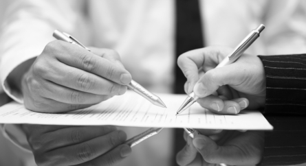 Two people signing document