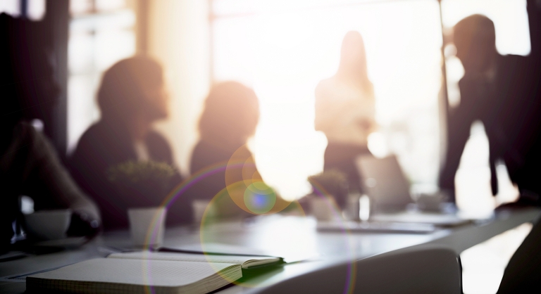 Blurred image of a staff meeting.