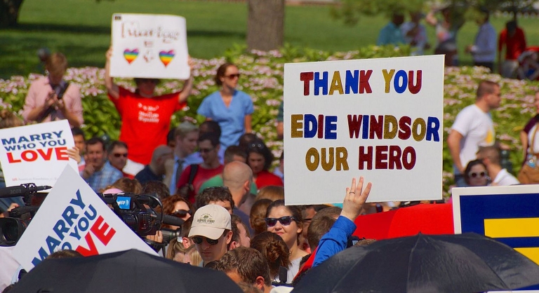 Hand-made sign at a parade that says "Thank you Edie Windsor our hero".