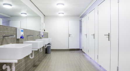 sinks in a bathroom and closed doors to stalls