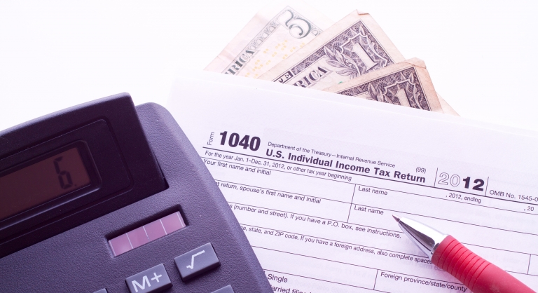 U.S. Individual Income Tax Return with a calculator and money.