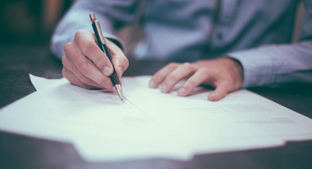 A person signing a contract.