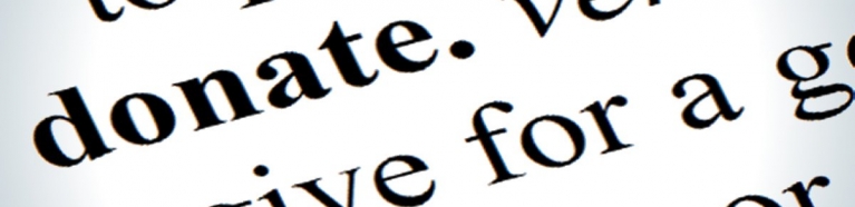 Close-up dictionary definition of the word donate.