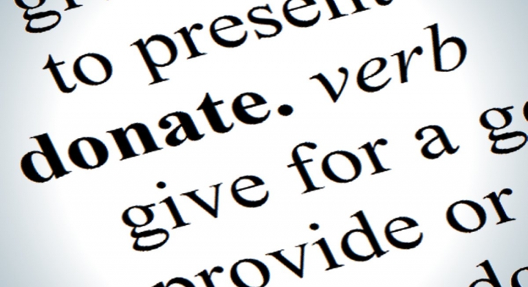 Close-up dictionary definition of the word donate.
