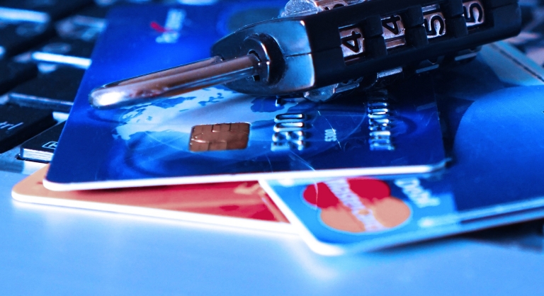 Padlock and credit cards on a laptop keyboard.