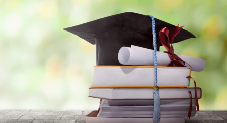 graduation cap with diploma and books