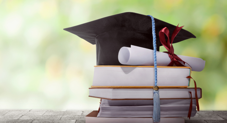 graduation cap with diploma and books