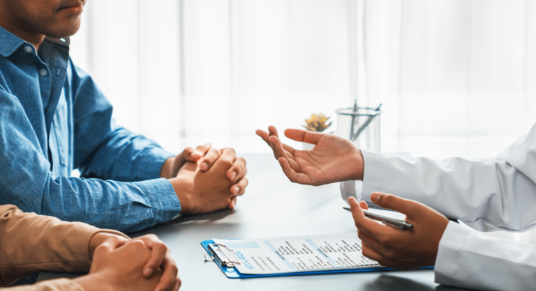 Doctor talking to a male and female couple at a desk