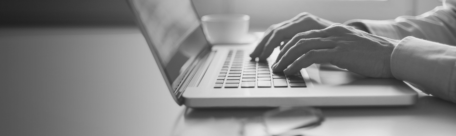 Close-up of hands typing on a laptop.