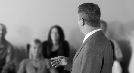 A male lawyer addressing a jury.