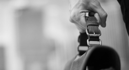 Close-up of hand holding a briefcase.