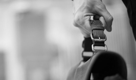 Close-up of hand holding a briefcase.