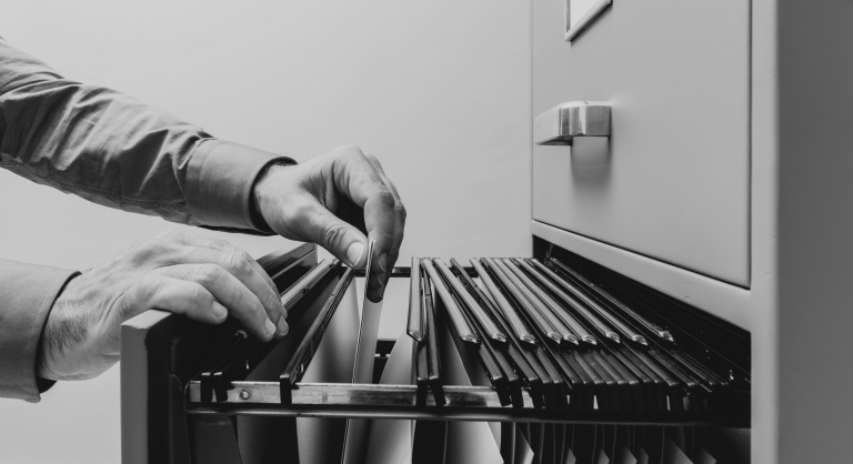 Person going through a filing cabinet.