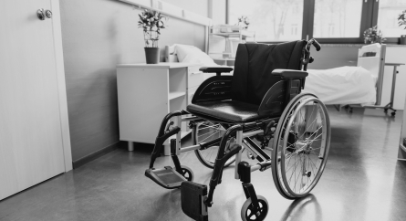 Empty wheelchair in an empty hospital room.