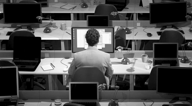 Lone employee still working in an empty office.