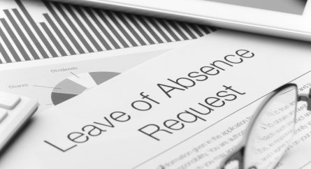 Leave of absence request form on a desk with paperwork