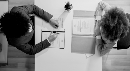 Employees at a table with documents in front of them having conversation.