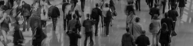 Blurry image of people walking in a crowded area.