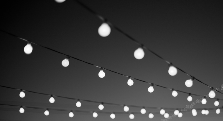 Hanging outdoor string lights with outer edges blurred.