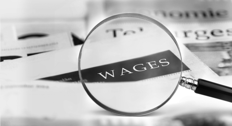 magnifying glass and the word wages on a piece of paper