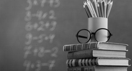 School books, pencil and chalkboard