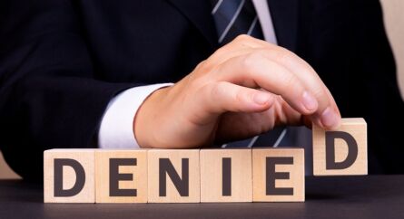 Man Made Word Denied With Wooden Blocks. Business Concept.