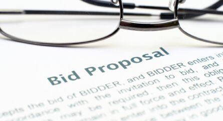 A document with the words bid proposal and a pair of glasses