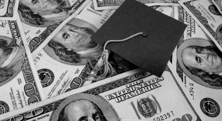 Graduation cap on a pile of money.