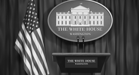 Podium speaker tribune with USA flags and sign of White House.